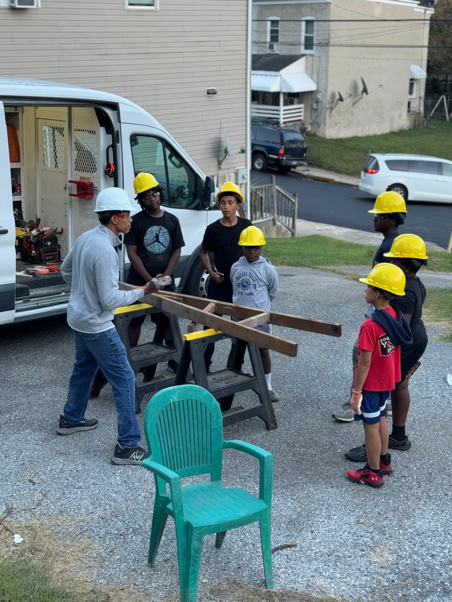 Mentor teaching a group of participants with lumber on sawhorses